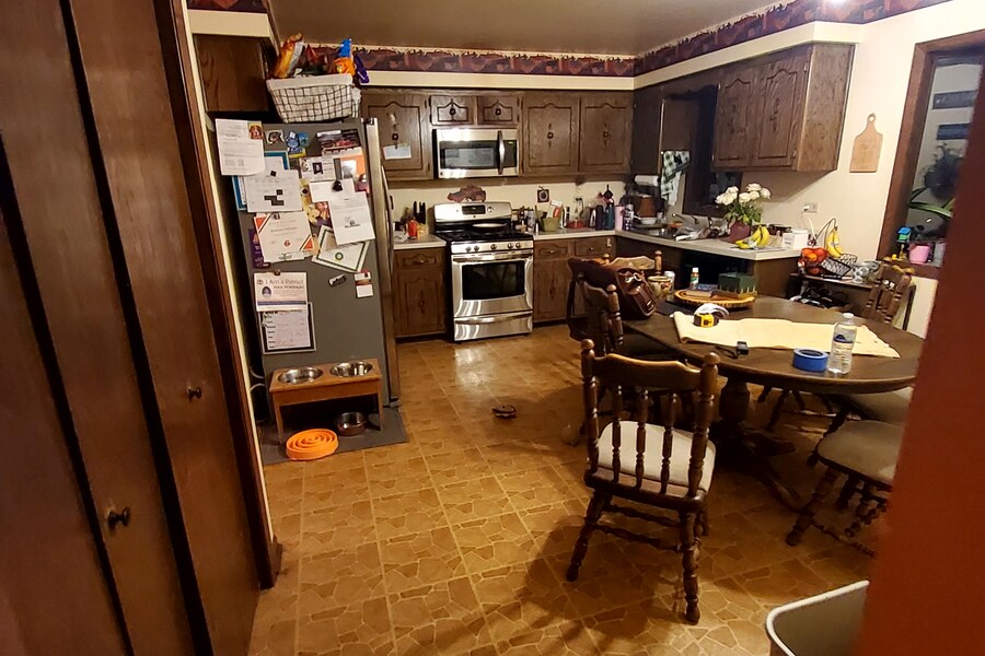 Before: cluttered dated kitchen with dark cabinets and old tile floor