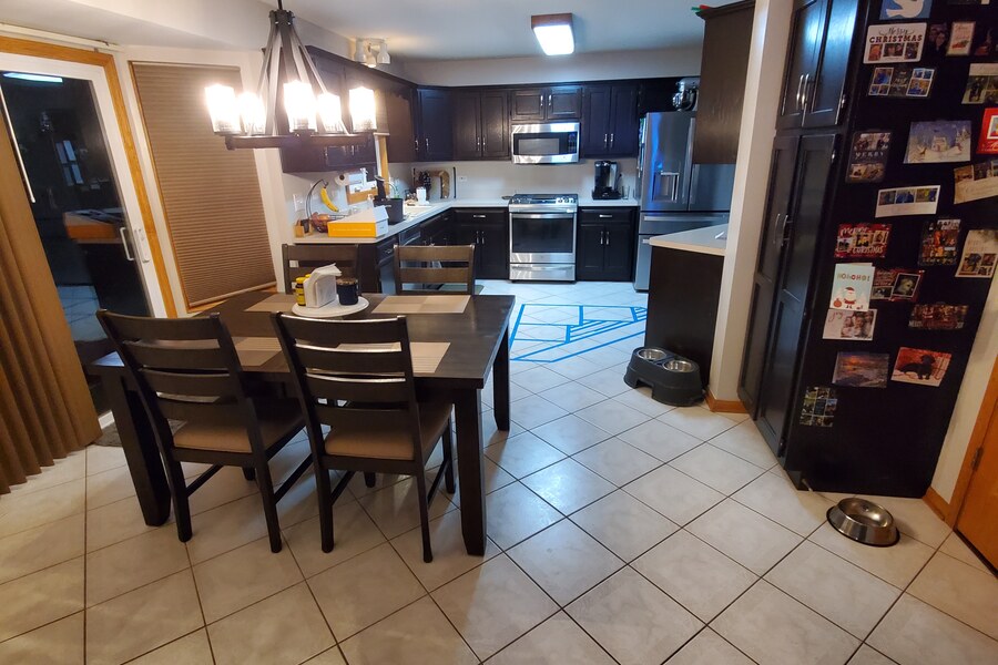Before: dated kitchen with black cabinets and white tile floor